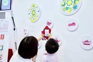 子どもたちがスマホで壁のイラストをかざして遊んでいる