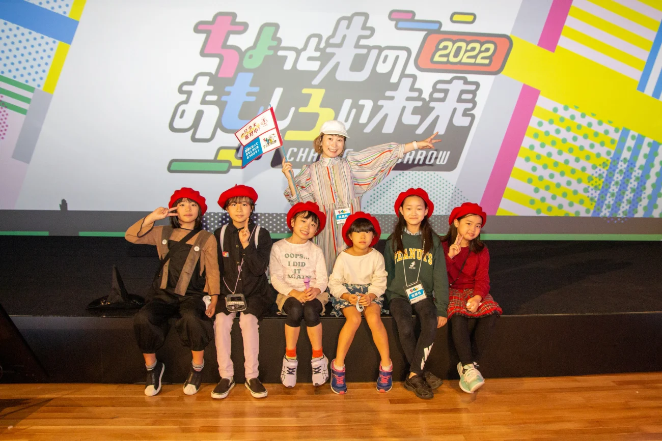 大人と子どもたちがステージに並び、笑顔でポーズをとっている