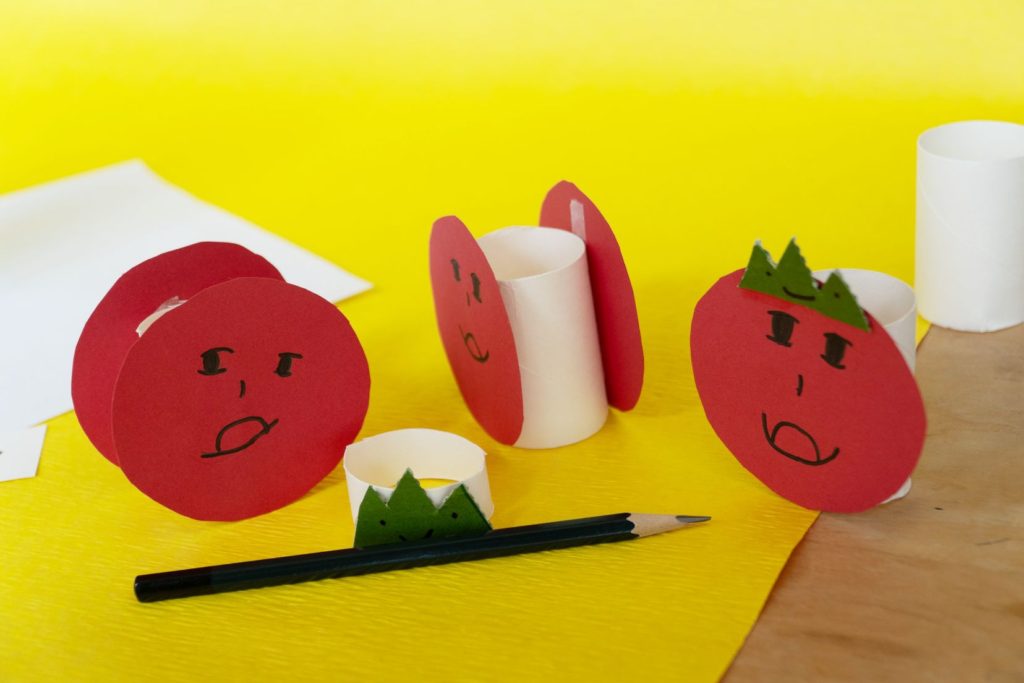 紙コップと赤い紙で作った顔のキャラクターと鉛筆