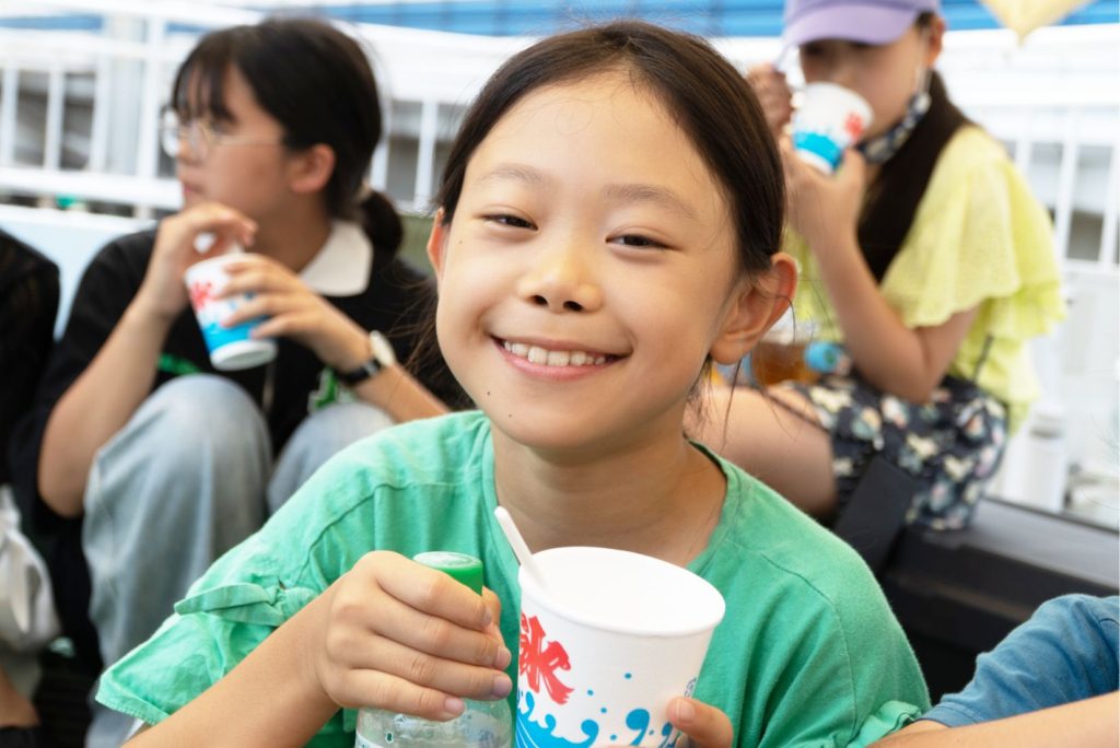 笑顔でかき氷を持つ子どもと他の子どもたち