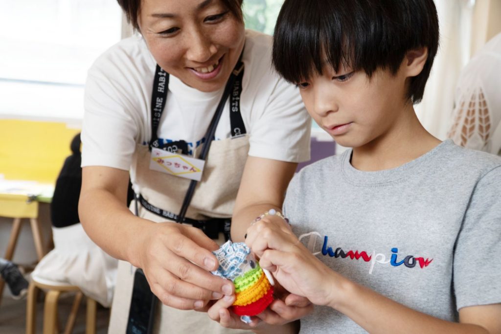 女性講師が子供にコマ撮り人形の作り方を教えている