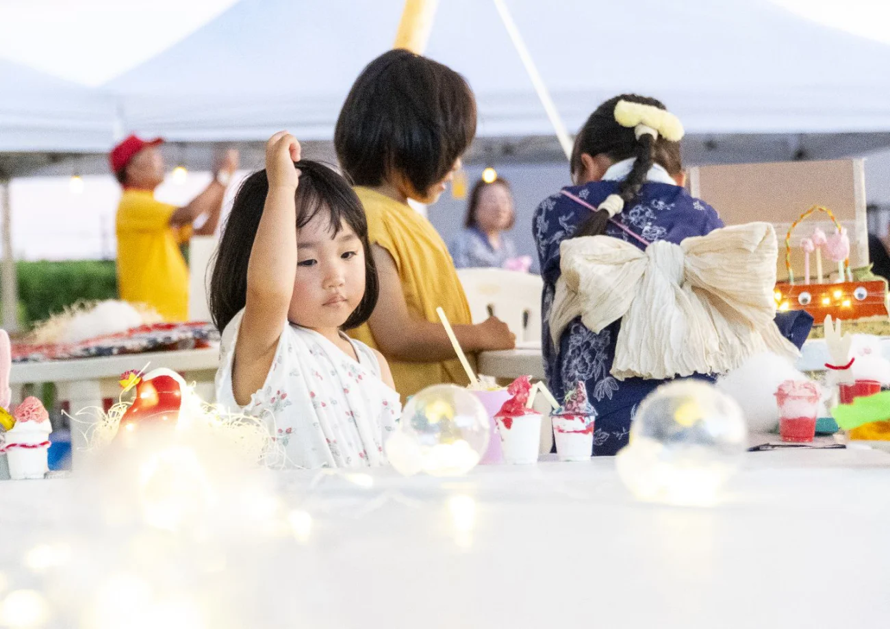 浴衣の子どもたちがテーブルで何かを見ている様子