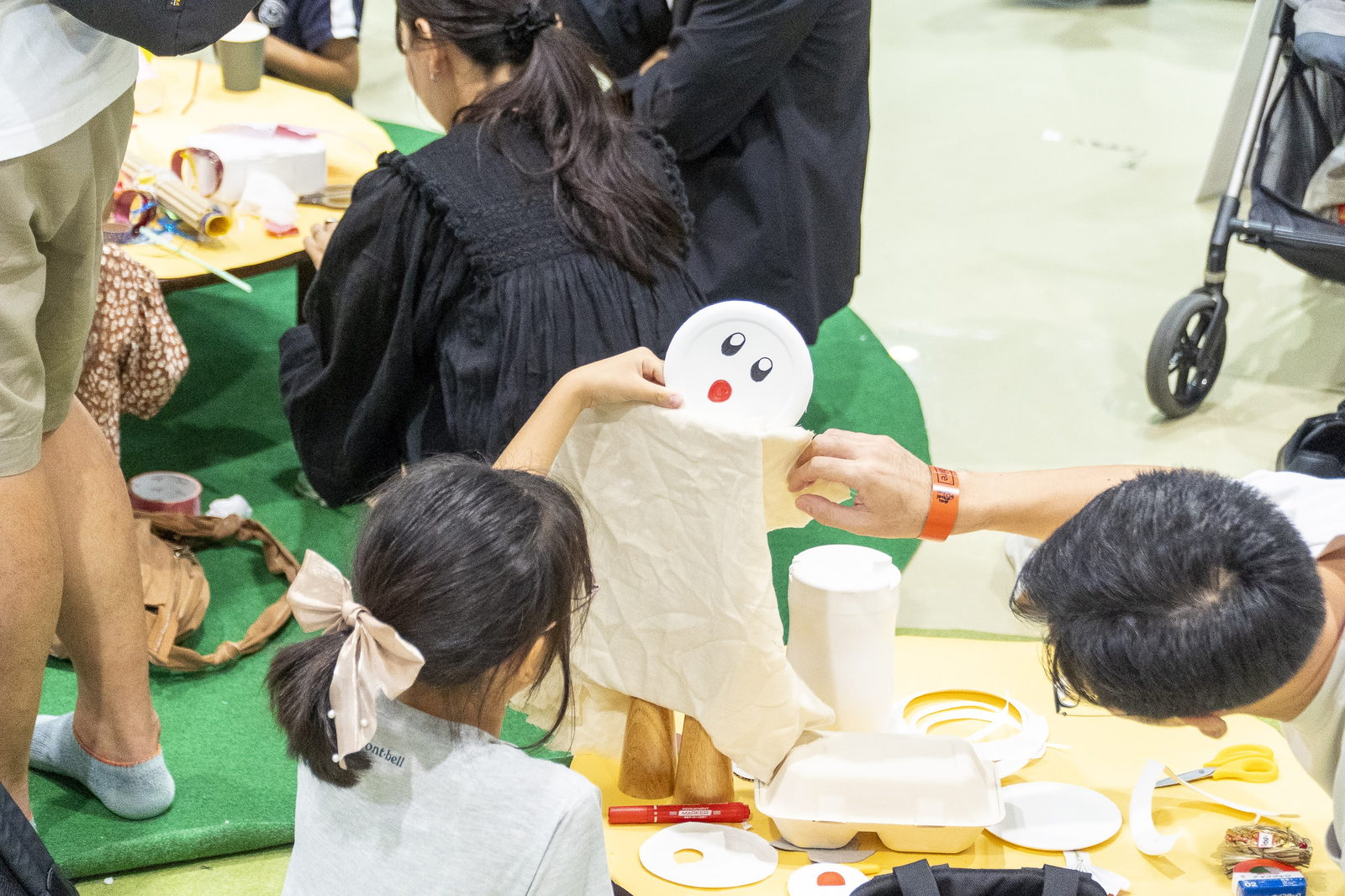 紙皿と布で作品づくりをする親子
